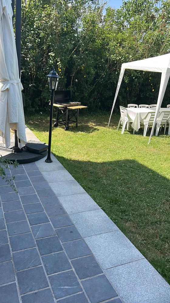Vue sur la pelouse depuis la terrasse avec lampadaire