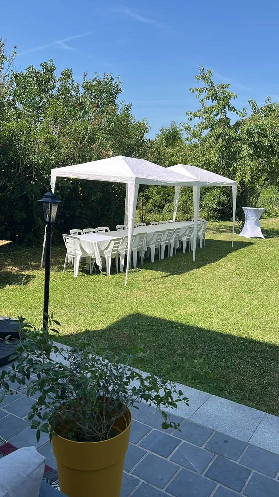 Chapiteau blanc installé sur la grande pelouse par ciel bleu