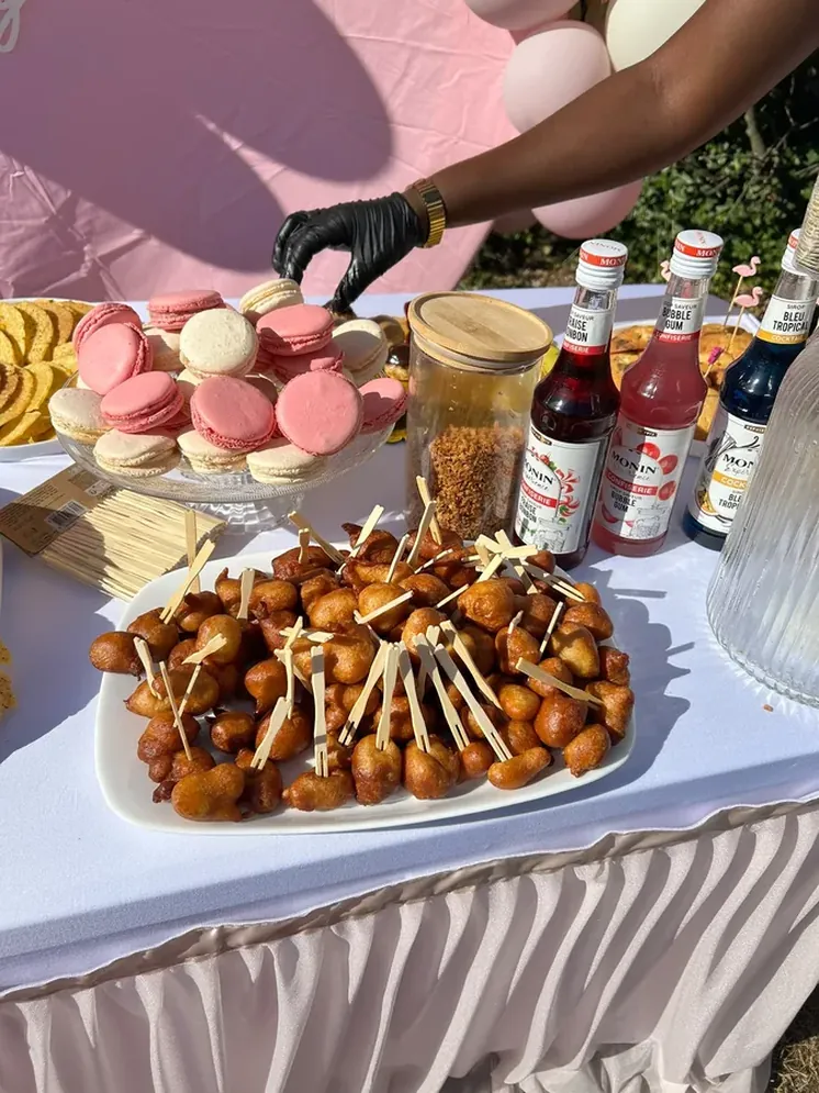 Table de réception avec macarons, beignets et sirops pour un anniversaire