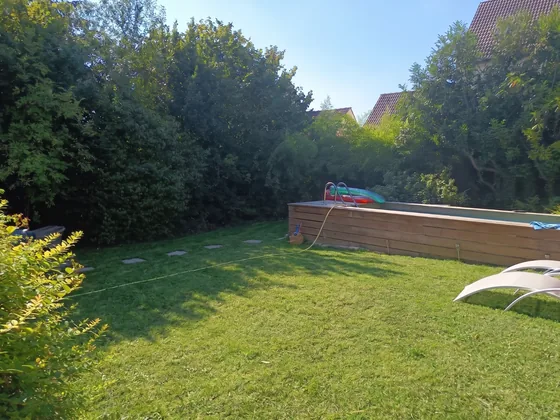 Allée dallée traversant la pelouse jusqu'à la piscine du jardin de Sarcelles